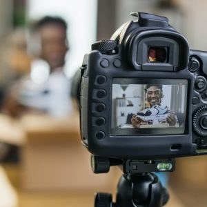 Afro american man unboxing sneakers and recording video