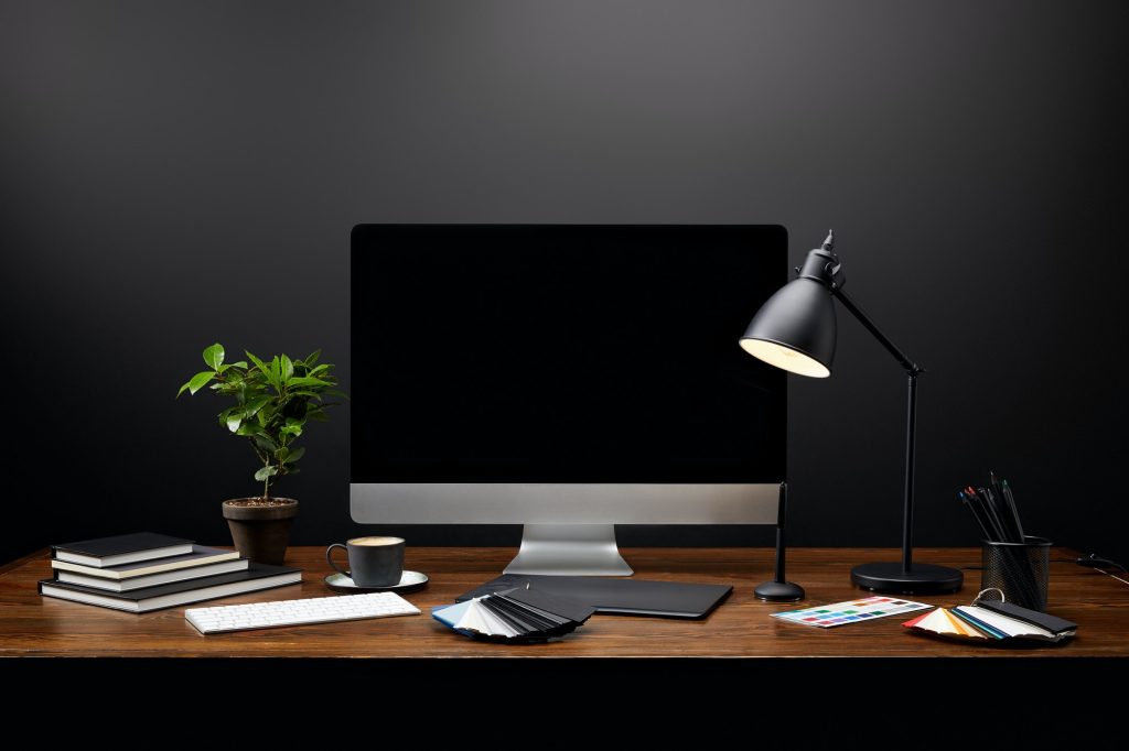 close up view of graphic designer workplace with graphic tablet, blank computer screen, notebooks