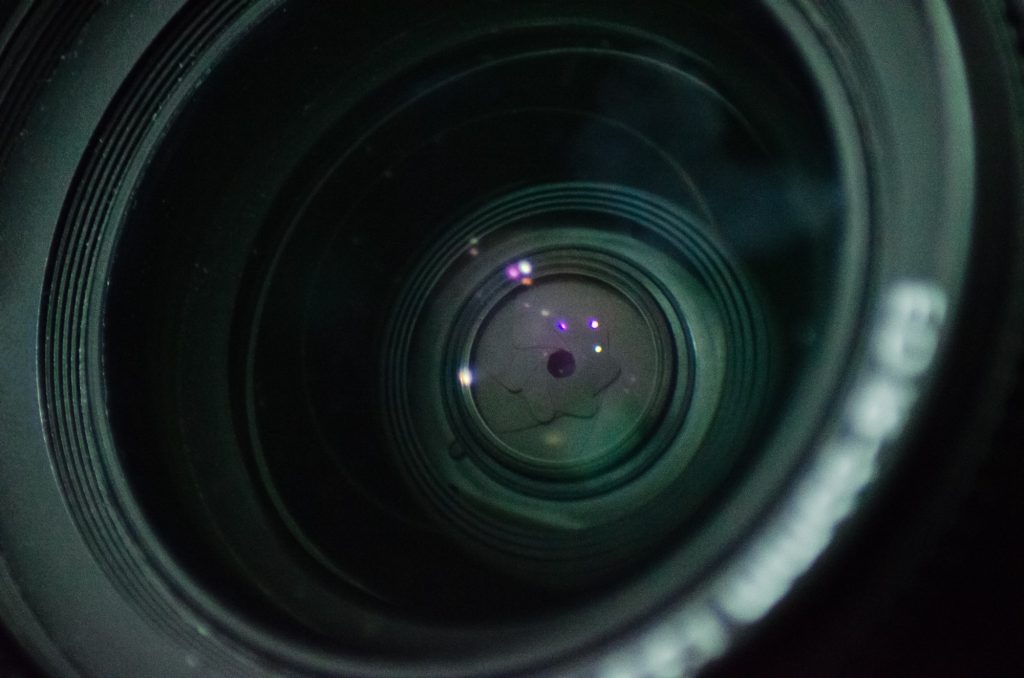 Macro shot of front element of a camera lens with beautiful color lights reflections photography